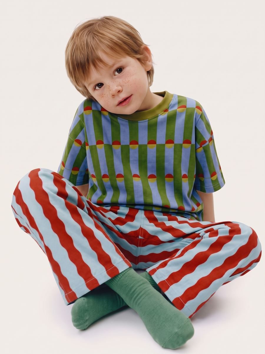 Child model sitting on a white background wearing the outfit